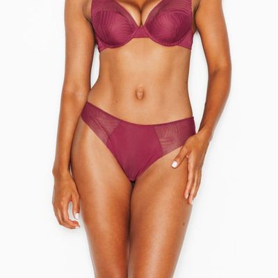 La femme en bikini violet prend la pose devant l'appareil photo.