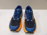 the pair of blue and orange running shoes are on a white surface