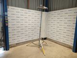 an image of a tripod stands in front of a wall with a backdrop