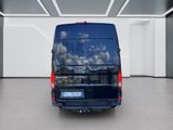 the rear view of a blue van parked in a large room
