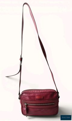 the small red bag is sitting on a white surface