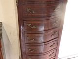 a wooden chest of drawers with a mirror on top of it