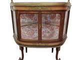 an antique display cabinet with a glass door and gold trimming