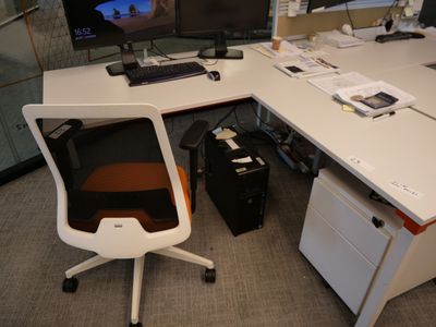 un bureau d'ordinateur sur lequel se trouvent une chaise et un écran d'ordinateur