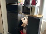 a black refrigerator and a black cabinet in a room