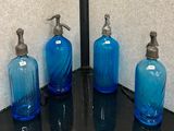 trois bouteilles en verre bleues posées sur un comptoir noir