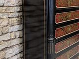 a black and gold chest of drawers in front of a brick wall