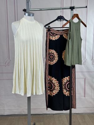 two dresses hanging on a clothes rack in a room
