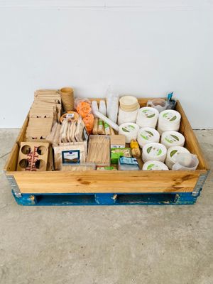 une caisse en bois posée par terre et contenant divers objets
