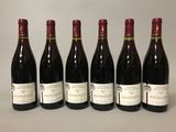 six bouteilles de vin sont alignées sur une table