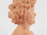 marble bust of a boy with curly hair on a white background