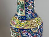 a blue vase with a gold handle sitting on a table