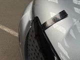 a sticker on the hood of a car that is parked in a parking lot