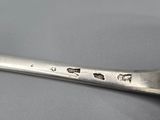 silverware spoon with holes in it on a gray surface