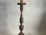 un lampadaire ancien en bois surmonté de deux lampes