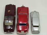three toy cars are lined up in a row on a white surface