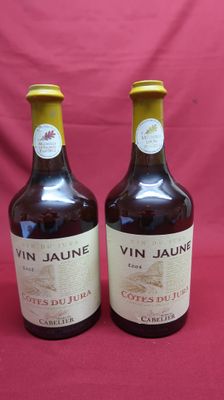 two bottles of wine are sitting on a red cloth