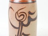 a brown vase with a design on it on a white surface