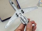 someone is holding a model airplane in their hand on a table