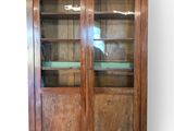 an image of a wooden cabinet with glass doors and shelves