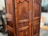 a wooden armoire in the middle of a room