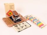 un appareil photo Polaroid et quelques livres posés sur une table