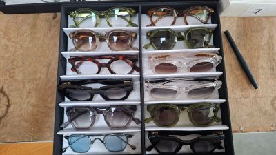many pairs of sunglasses sitting in a black case