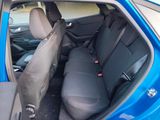 the back seats of a blue car with a black seat belt