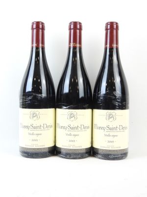 trois bouteilles de vin sont alignées sur une surface blanche