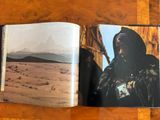 an open book with a picture of a man in the desert
