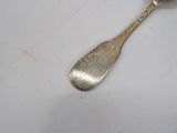 a silver spoon with a handle on a white surface