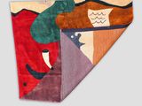 an image of a colorful rug with a woman and a bird on it