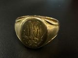 an image of a gold signet ring with a monogram on it