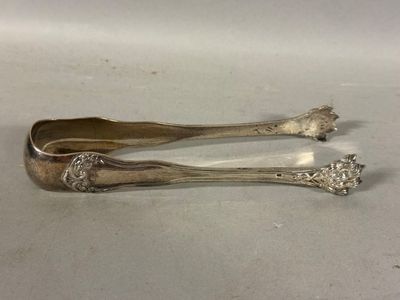 une paire de cuillères anciennes en argent posées sur une surface blanche