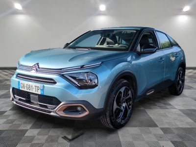 une voiture bleue est garée dans une pièce au sol à carreaux