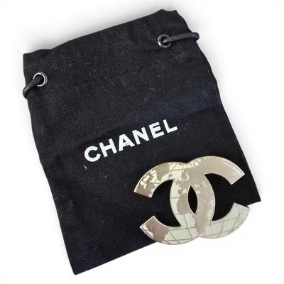 chanel brooch in a black bag with a white logo on it
