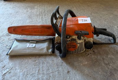 a chainsaw sitting on the floor next to a bag