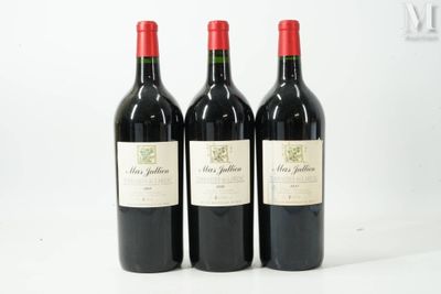 trois bouteilles de vin rouge posées sur une table blanche