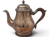 an old silver tea pot with a handle and a handle