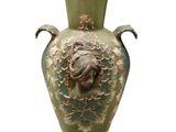 a large green vase with a lion head on it