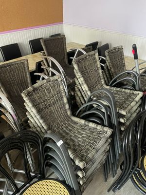 de nombreuses chaises et tables dans une pièce où se trouvent une table et des chaises