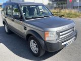 Le Land Rover gris est garé devant un immeuble