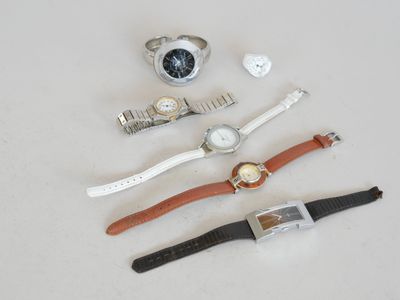 trois montres et une montre posées sur une surface blanche