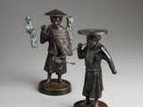 pair of bronze figurines of a man and a woman holding fish