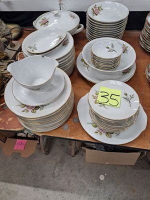 de nombreuses assiettes et bols posés sur une table, accompagnés d'une étiquette indiquant le prix