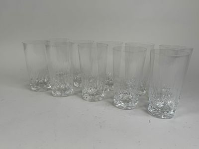 six clear glasses lined up in a row on a white surface