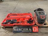 une caisse rouge contenant des outils, posée sur une palette