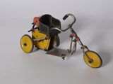 un petit tricycle jouet muni d'un panier à l'arrière