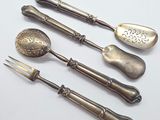 three silver spoons and a fork on a white surface
