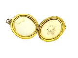 a close up of two gold lockes with a white stone inside